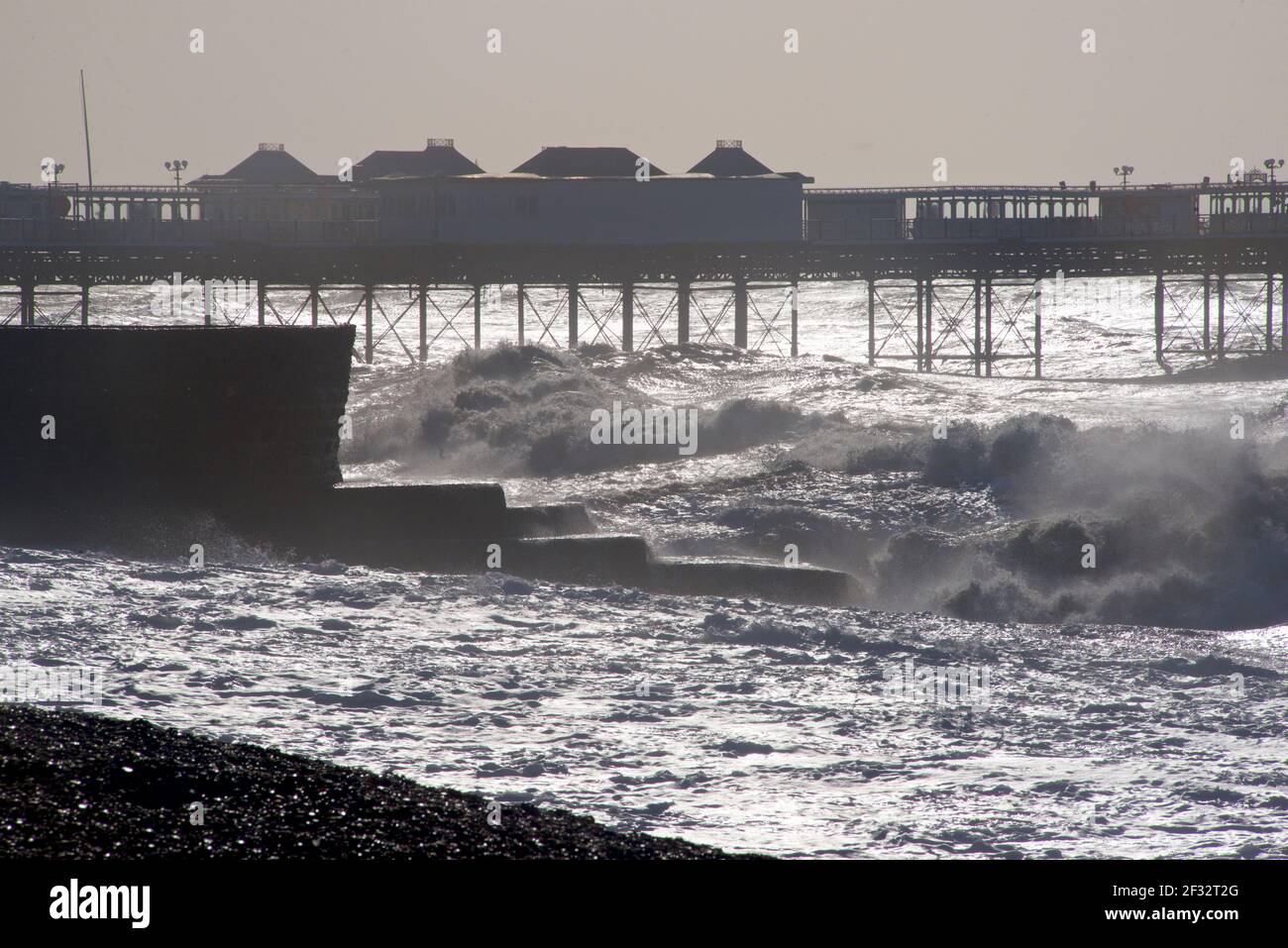 Looking east towards the Palace Pier, Brighton. Silhouette shapes and waves. Brighton beach on a stormy morning. East Sussex, England, UK. Stock Photo