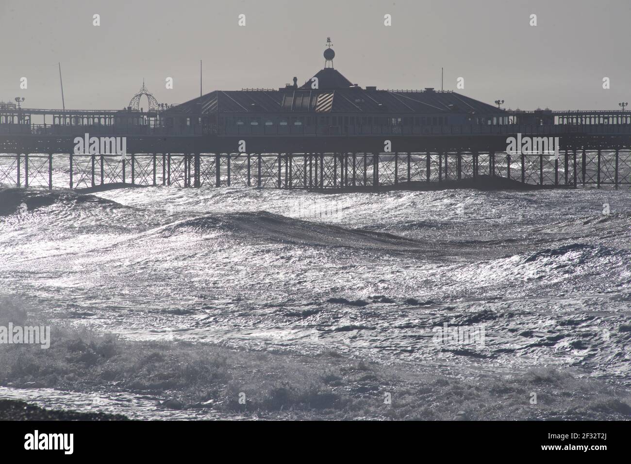 Looking east towards the Palace Pier, Brighton. Silhouette shapes and waves. Brighton beach on a stormy morning. East Sussex, England, UK. Stock Photo