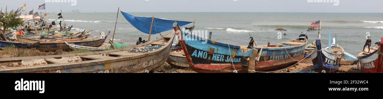 Fishing village beach shore near Accra Ghana. Old handmade fishing boats. Hand build boats. Poor sanitation, poor neighborhoods. Stock Photo