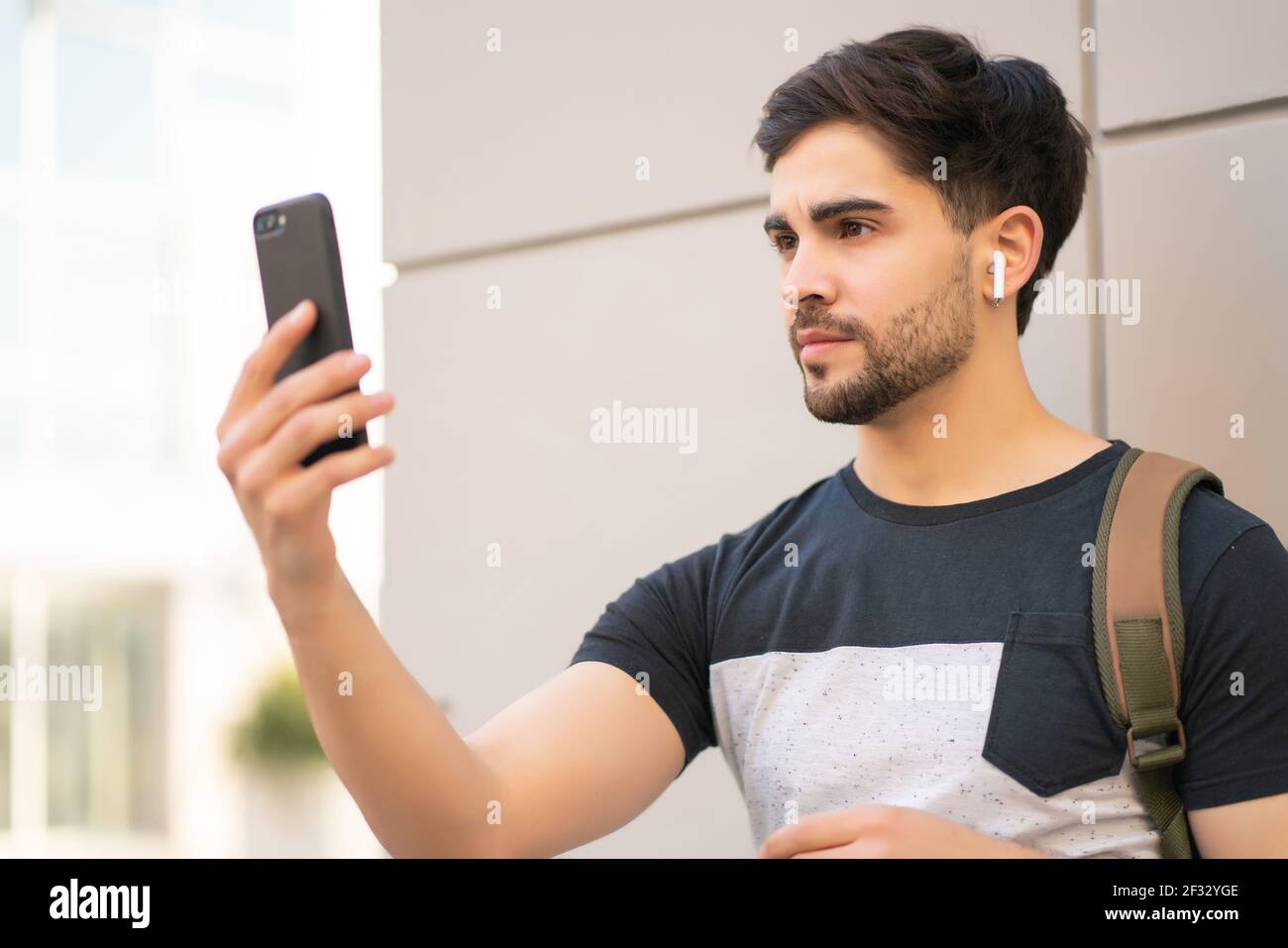 Young man using face id for unlock mobile phone outdoors. Stock Photo