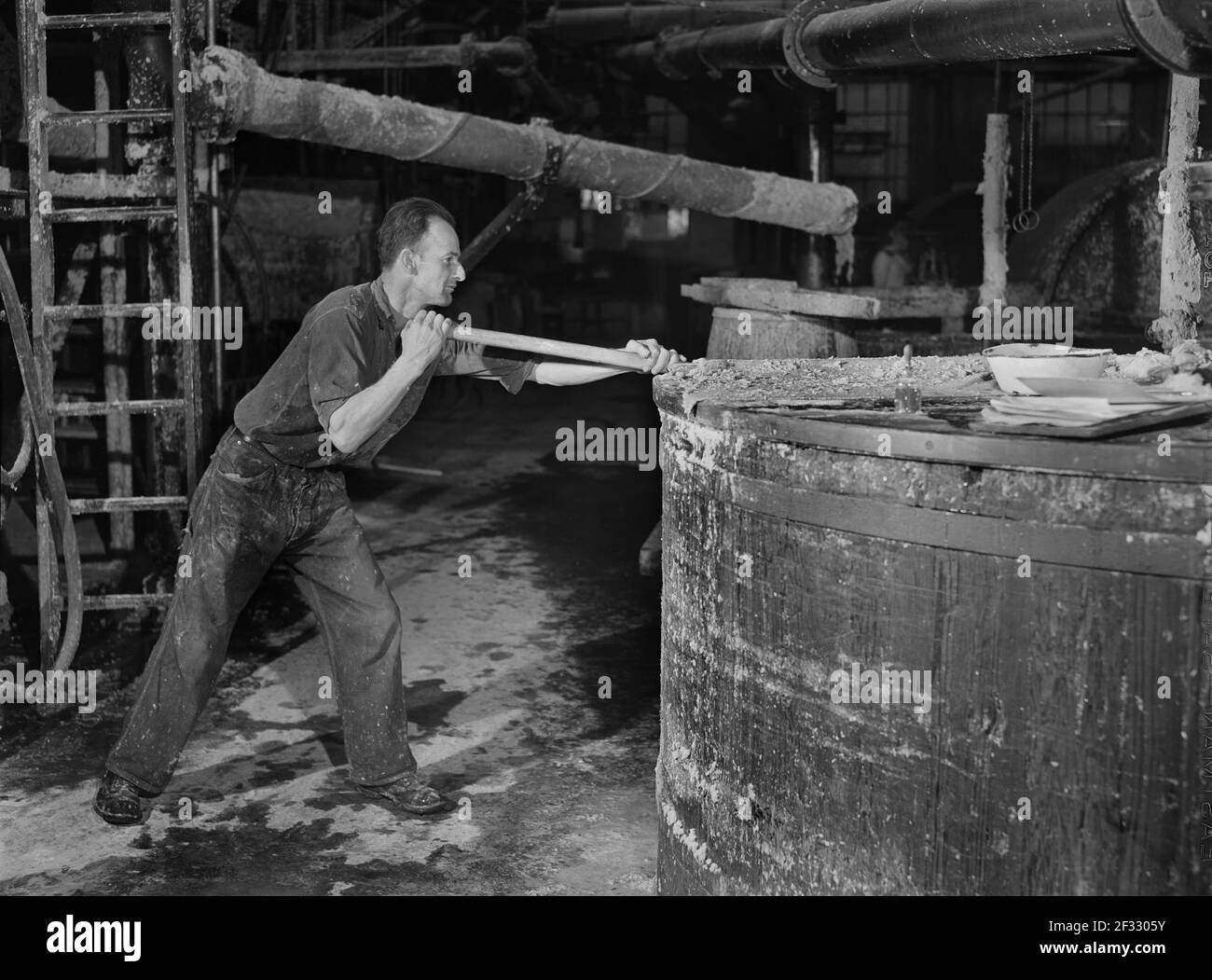 Worker stirring Paper Pulp in Large Vat, Mississquoi Corporation Paper Mill, Sheldon Springs, Vermont, USA, Jack Delano, U.S. Office of War Information, September 1941 Stock Photo