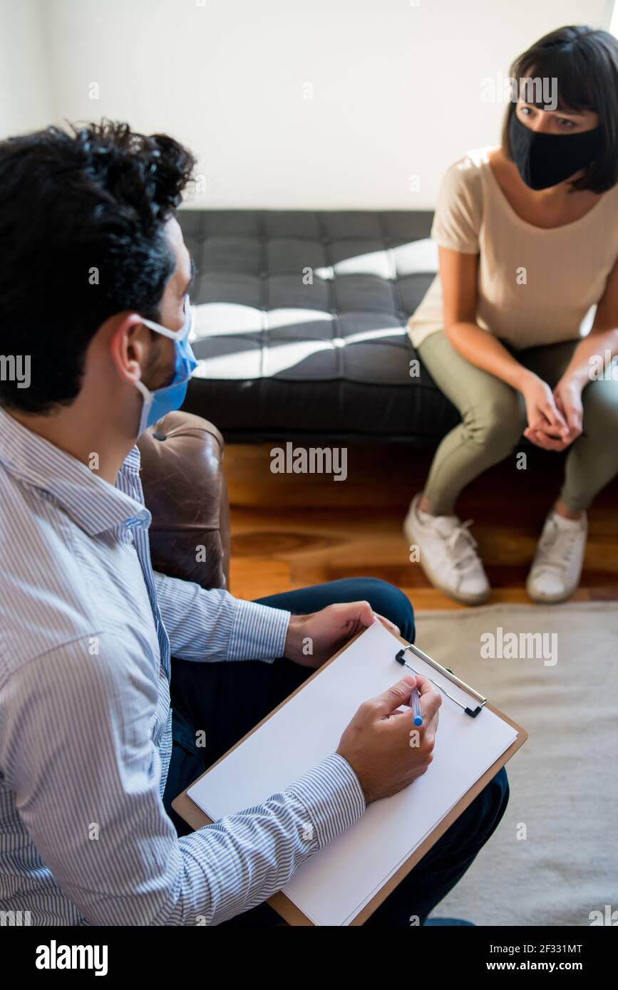 psychologist-taking-notes-during-therapy-session-stock-photo-alamy
