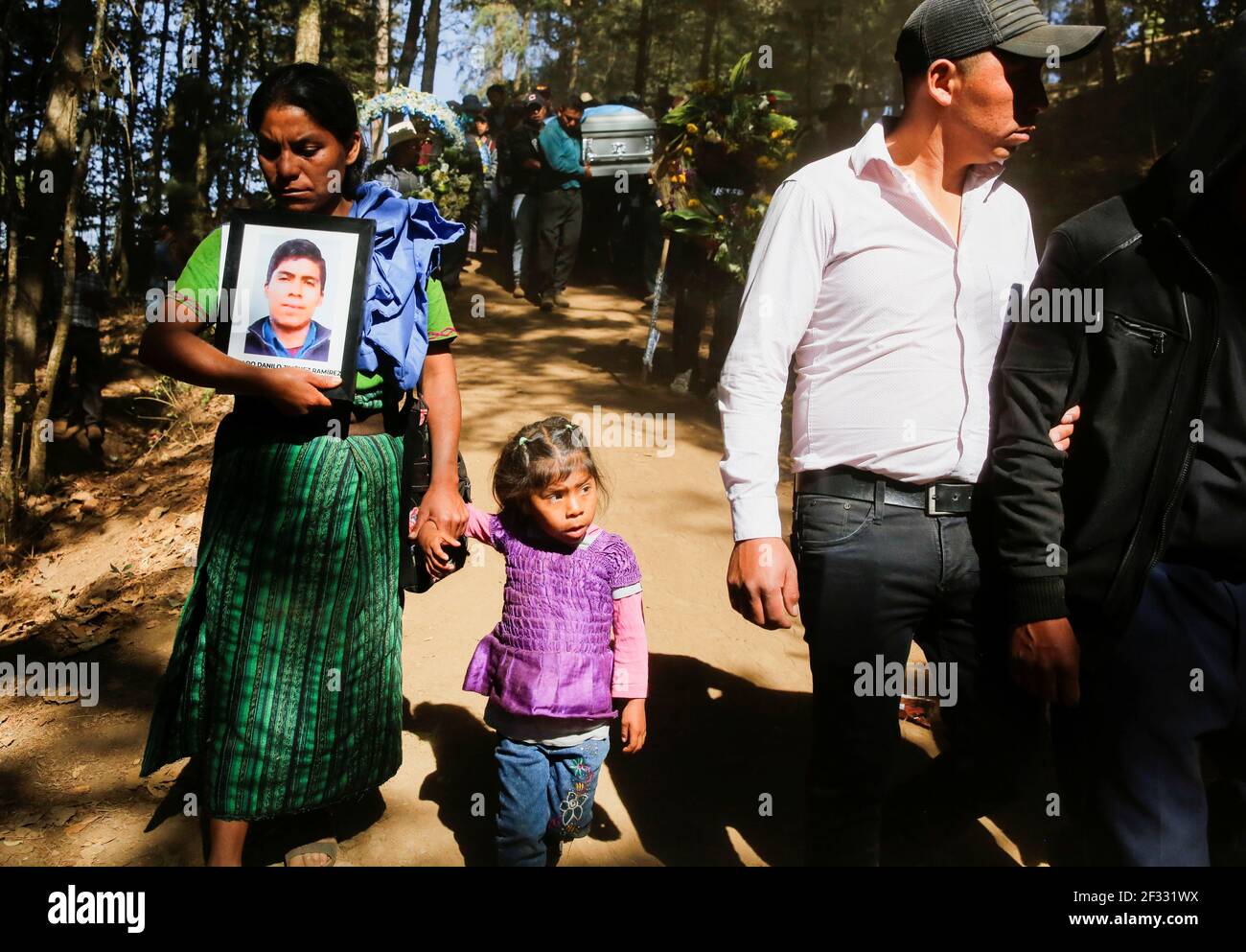 A relative carries a picture of Rivaldo Jimenez Ramirez, one of the  migrants killed in the Mexican state of Tamaulipas while trying to reach  the U.S., as others carry the coffing with
