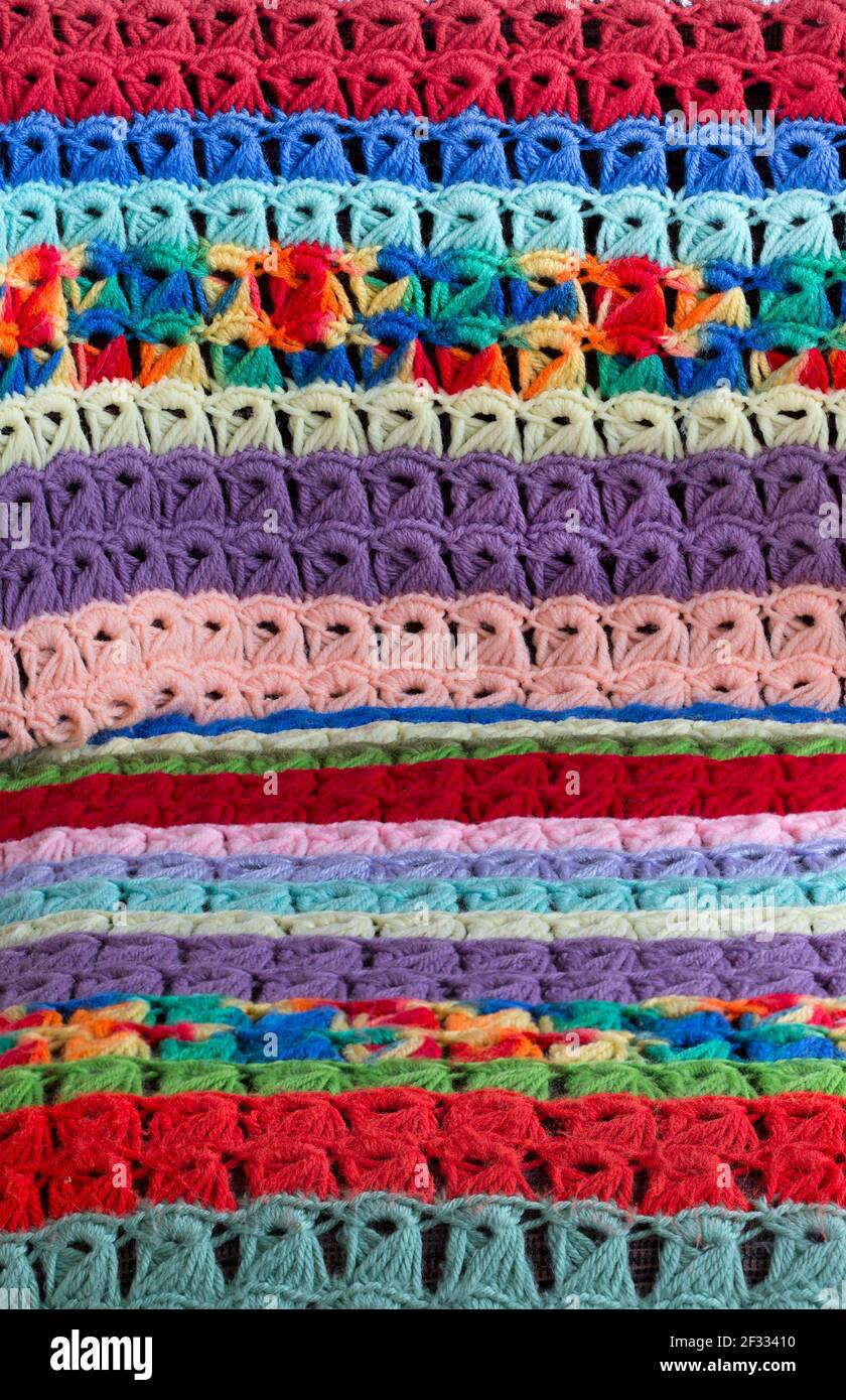 Detail of vintage colorful broomstick stitch lace crochet blanket draped over a chair created by American textile artist Margaret Braaten (1914-2004). Stock Photo