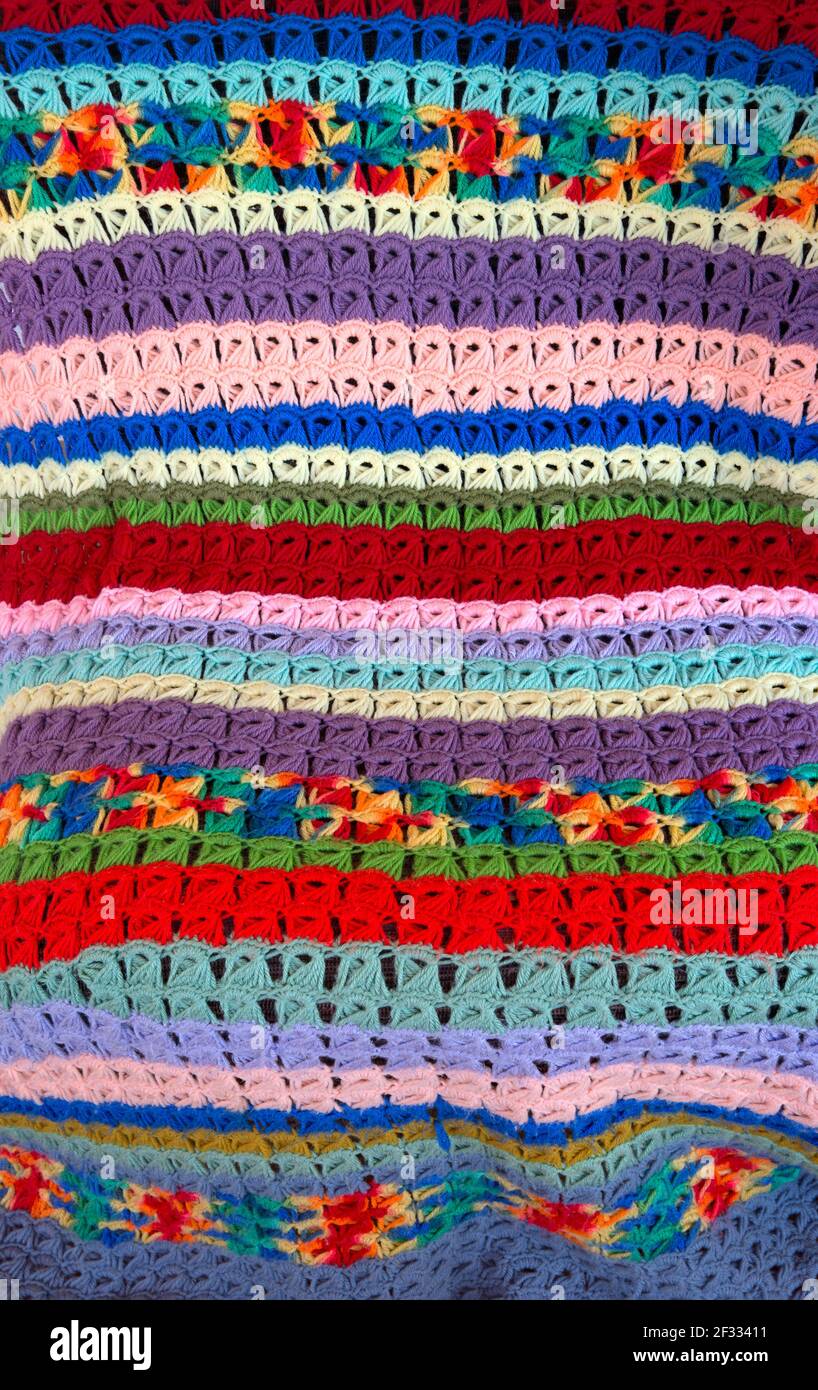 Detail of vintage colorful broomstick stitch lace crochet blanket draped over a chair created by American textile artist Margaret Braaten (1914-2004). Stock Photo