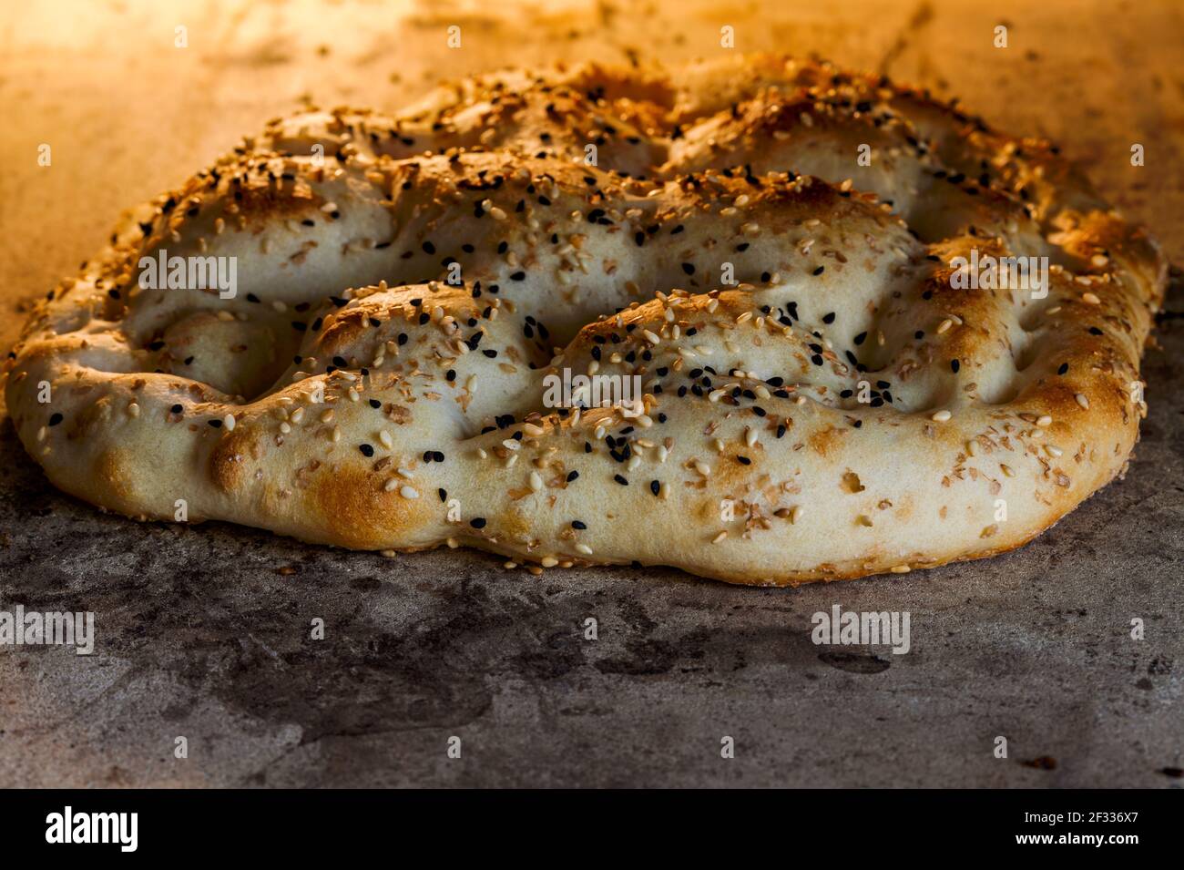 Ramazan pidesi is a type of Turkish flat bread (called pide) that is baked in wood fired stone ovens during the month of ramadan. A  bread is baking i Stock Photo
