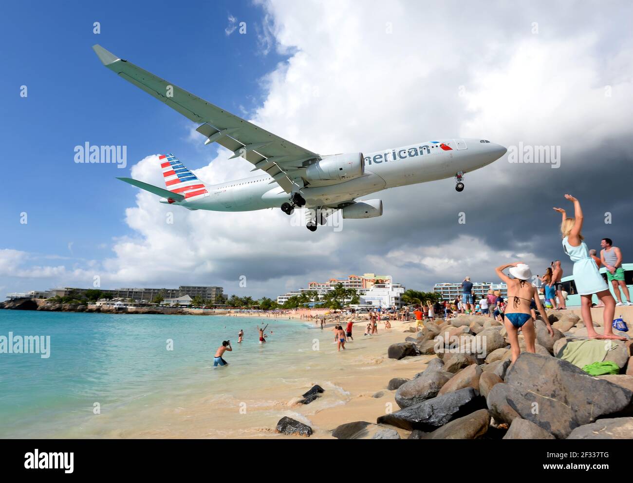 American Airlines Airbus A330 aircraft over Maho Beach in Saint Maarten Dutch Antilles. Airport beach in St. Maarten famous for airplanes passing over. Stock Photo