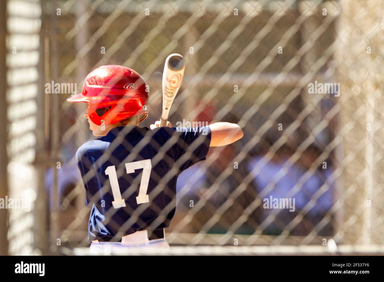 A red-headed teenage baseball player plays baseball in a youth league. Stock Photo