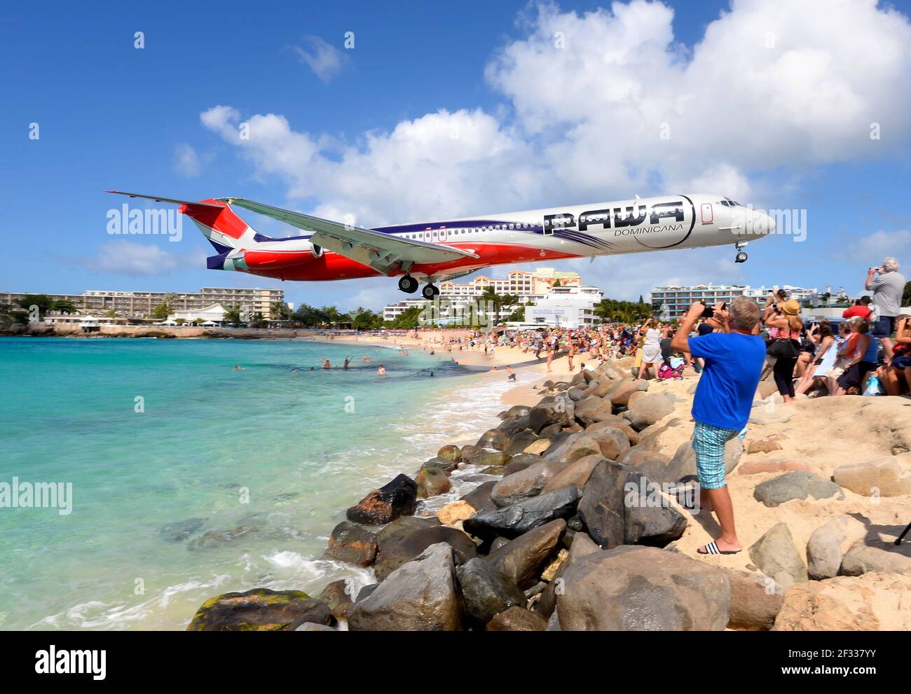 PAWA Dominicana MD-83 plane extreme low approach over Maho Beach, St. Maarten. Tourist attraction by the aircraft landing close above. Plane spotting. Stock Photo