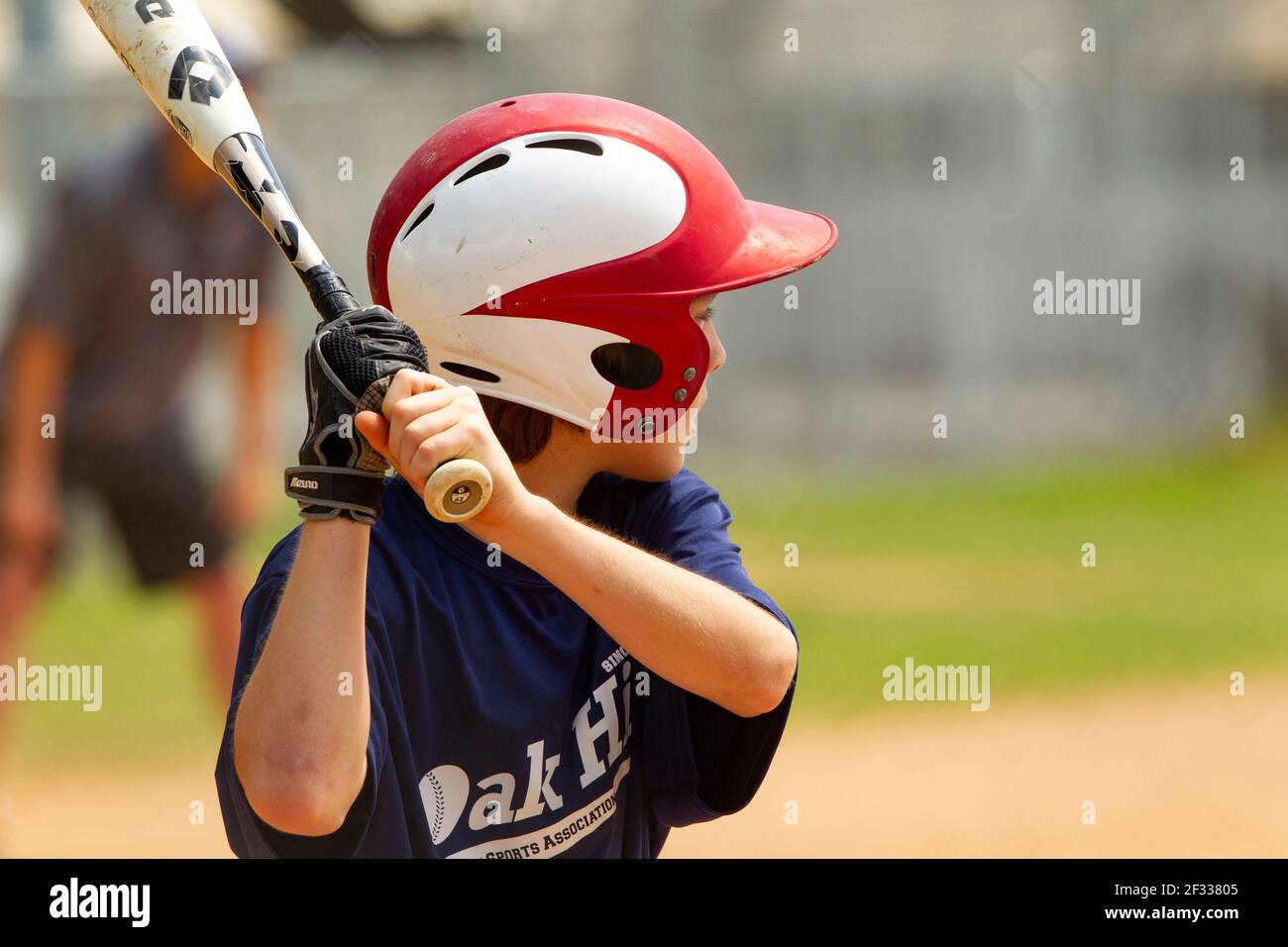 A teenage boy batting during a baseball game. Stock Photo