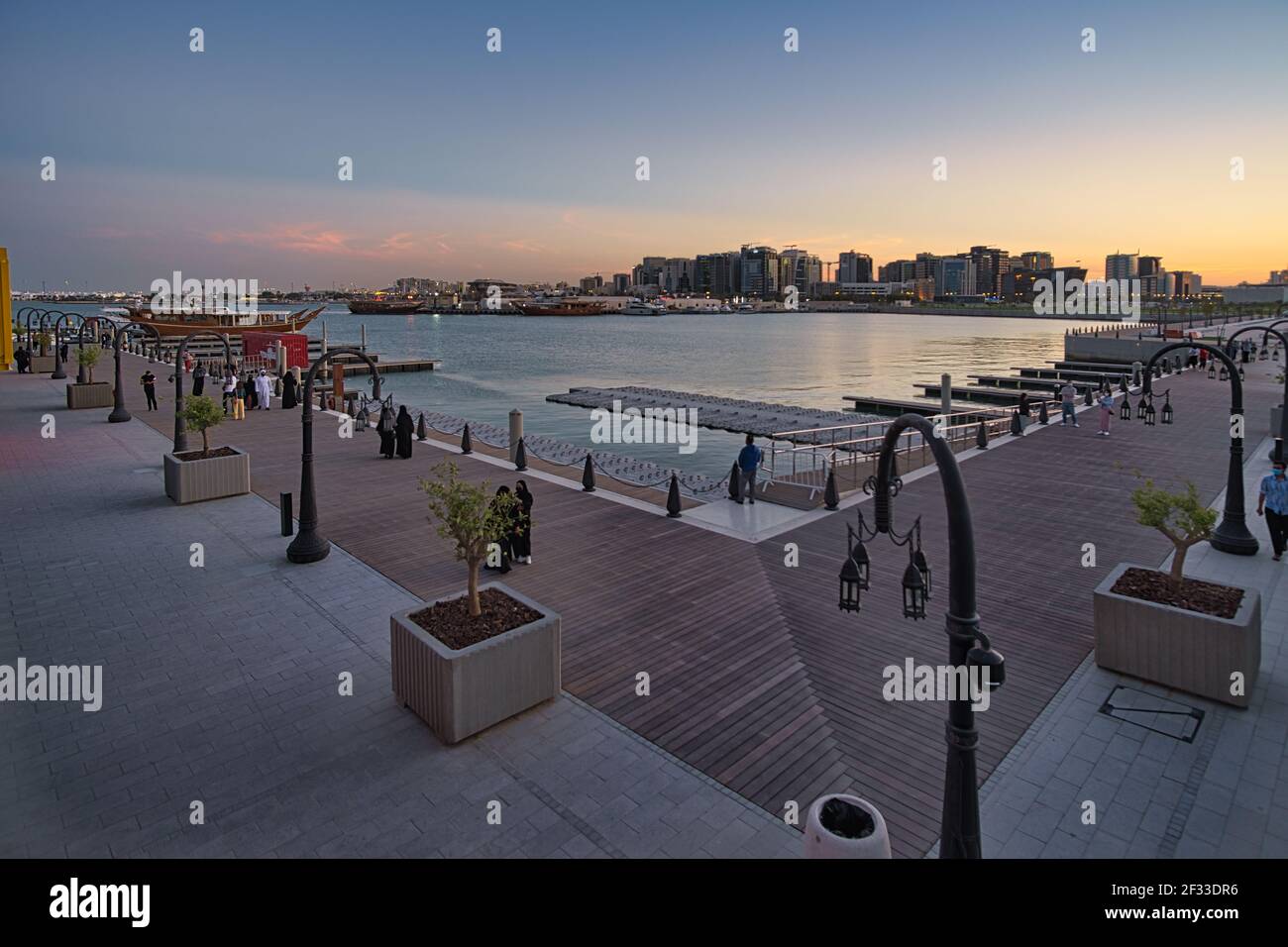 Box park in Doha Qatar at sunset showing locals and resident enjoying the park with dhows in the