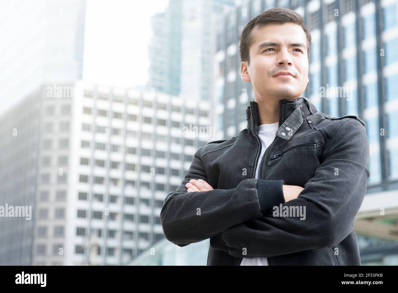 Handsome man with crossed arms standing in the city Stock Photo