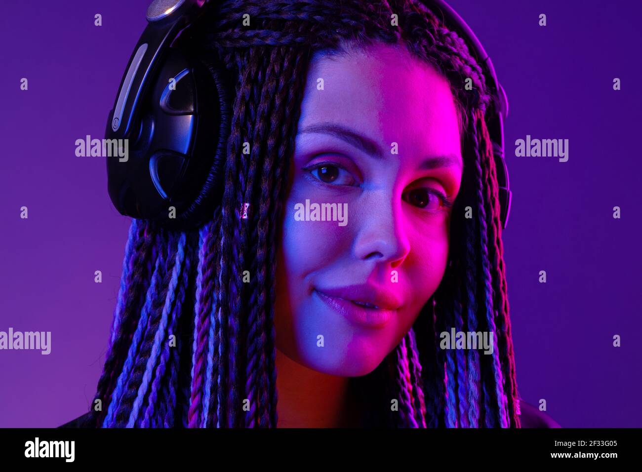 Beautiful woman with long hair in braids listening to music with ...