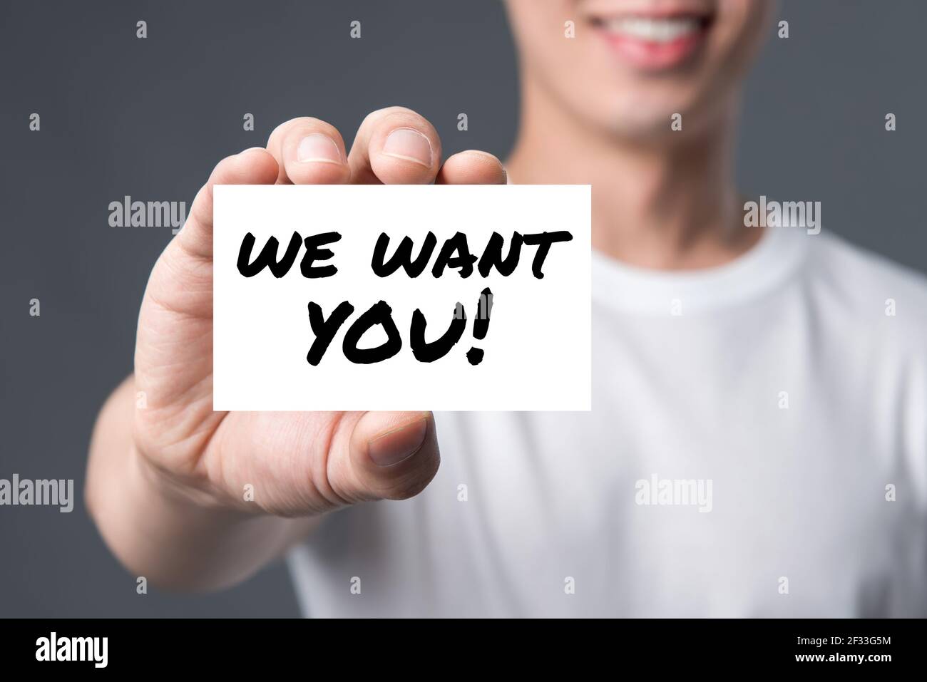 WE WANT YOU! message on the card shown by a man Stock Photo