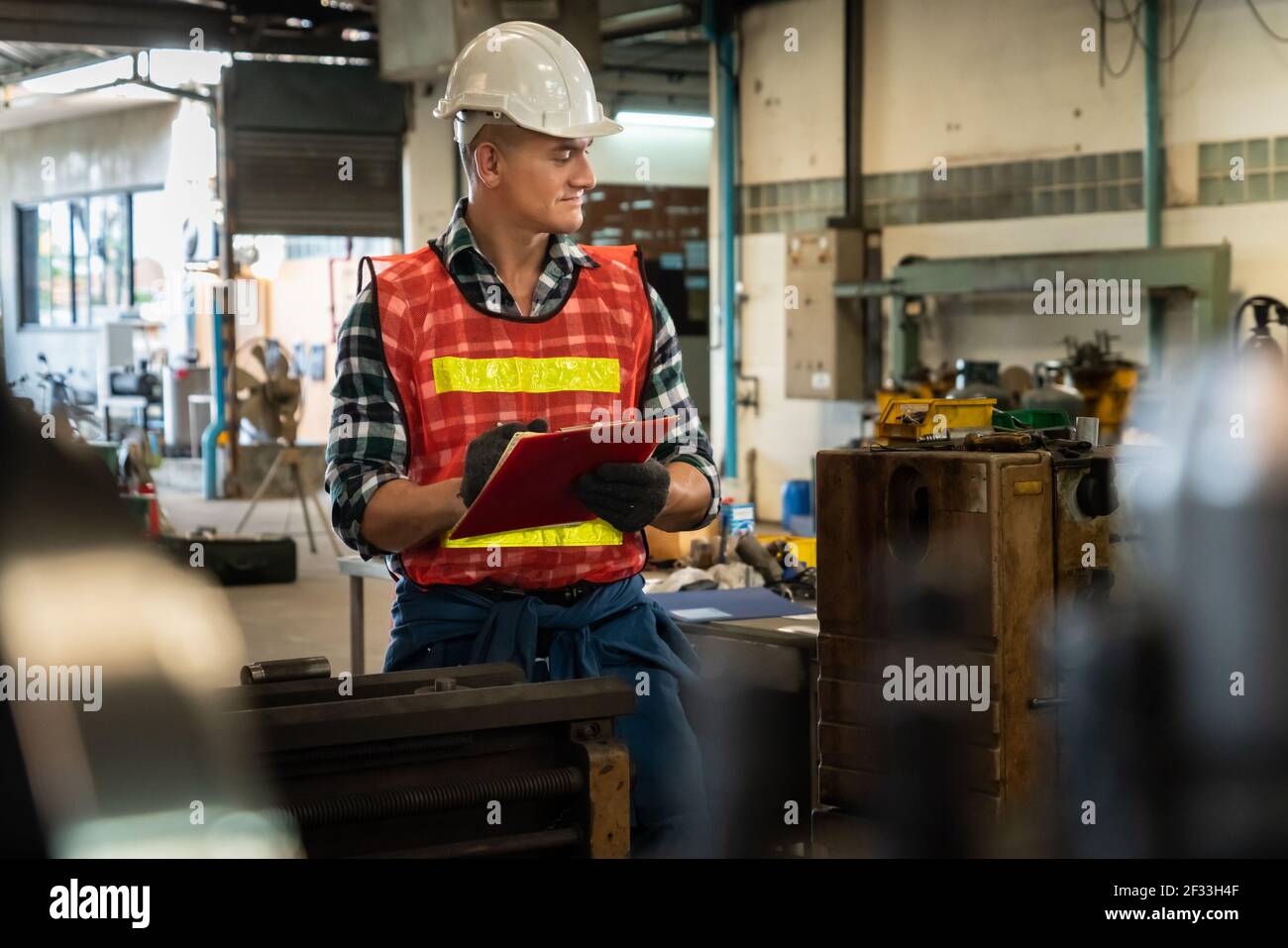 Manufacturing worker working with clipboard to do job procedure