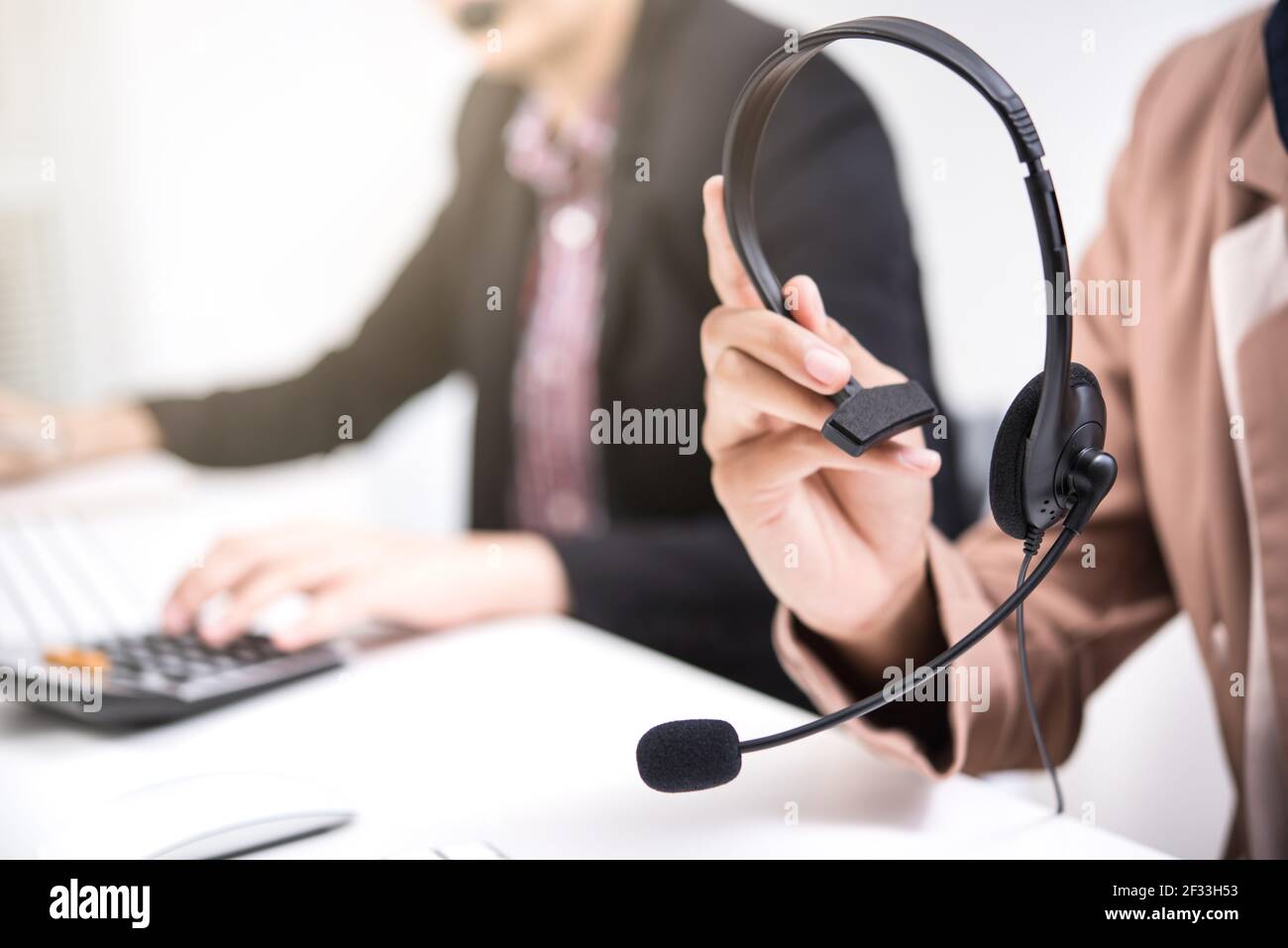 Woman hands holding microphone headset  - call center, telemarketer concepts Stock Photo