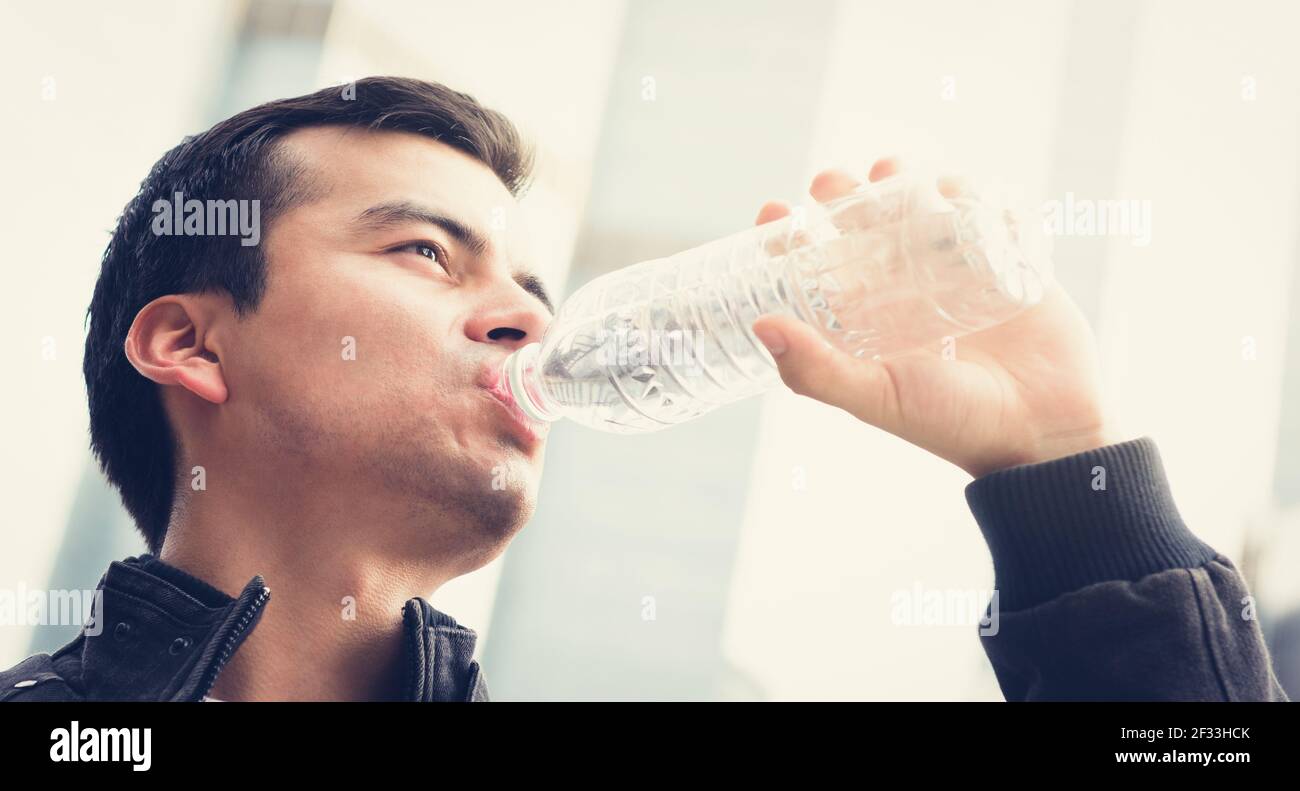 Young man drinking water from bottle, vintage tone effect Stock Photo
