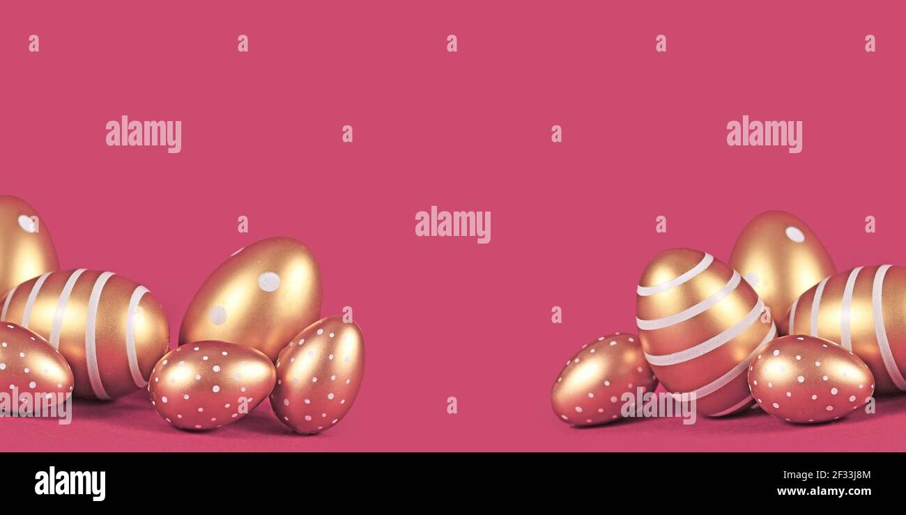 Banner with golden Easter eggs with simple stripe and dot pattern on pink background with copy space Stock Photo
