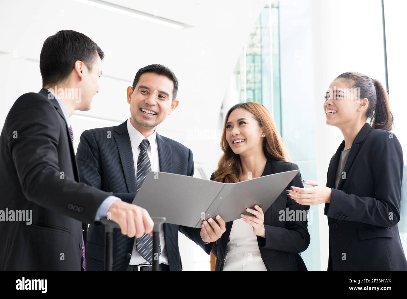 Happy business people discussing work in building hallway Stock Photo