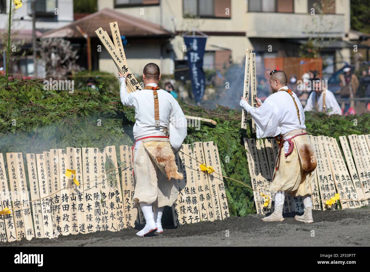 Hachioji, Japan. 14th Mar, 2021. Monks are seen preparing big bonfire.The Fire Walking Festival is held near Mount Takao every second Sunday of March. This year the programme of the Festival was shorter because of Covid19 pandemic, all people and some Monks were wearing face mask. The main attraction of Festival is the Monks walk barefoot across the embers of burning wood to cleanse themselves of evil spirits, pray for world peace, longevity, safe passage in life and general health and safety. (Photo by Takimoto Marina/SOPA Images/Sipa USA) Credit: Sipa USA/Alamy Live News Stock Photo