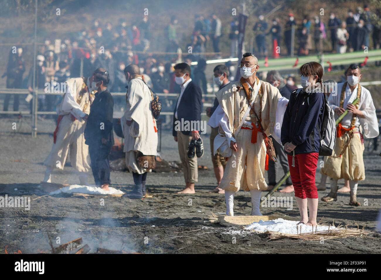 Hachioji, Japan. 14th Mar, 2021. People are seen preparing for the Fire Walking rituals.The Fire Walking Festival is held near Mount Takao every second Sunday of March. This year the programme of the Festival was shorter because of Covid19 pandemic, all people and some Monks were wearing face mask. The main attraction of Festival is the Monks walk barefoot across the embers of burning wood to cleanse themselves of evil spirits, pray for world peace, longevity, safe passage in life and general health and safety. (Photo by Takimoto Marina/SOPA Images/Sipa USA) Credit: Sipa USA/Alamy Live News Stock Photo