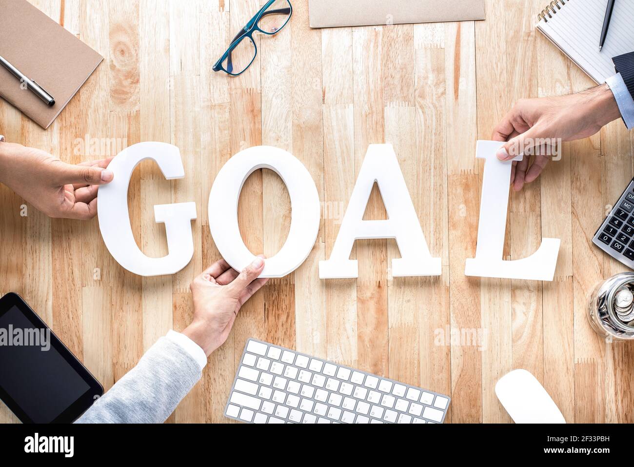 Business people hands arranging letters GOAL on working table -goal setting concept Stock Photo