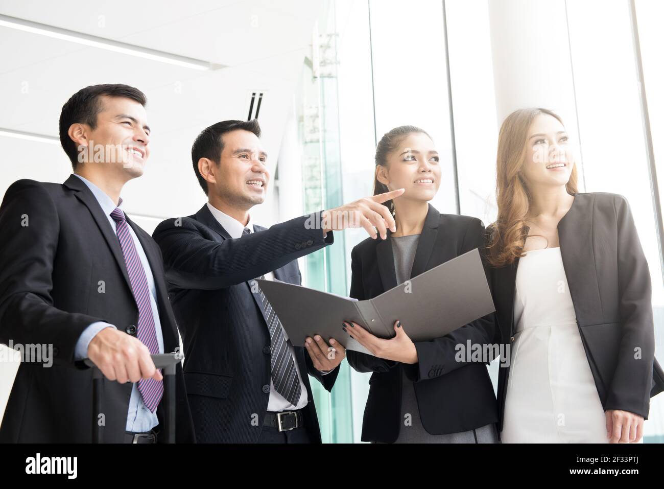 Group of business people discussing work in building hallway Stock Photo