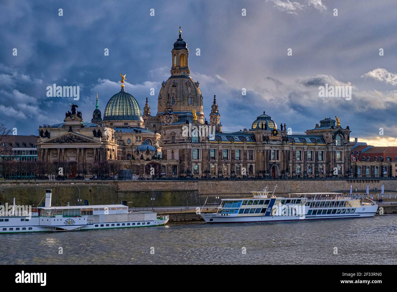 Dark storm clouds gather over the Church of our Lady and the Albertinum in the old part of town, seen across the river Elbe. Stock Photo