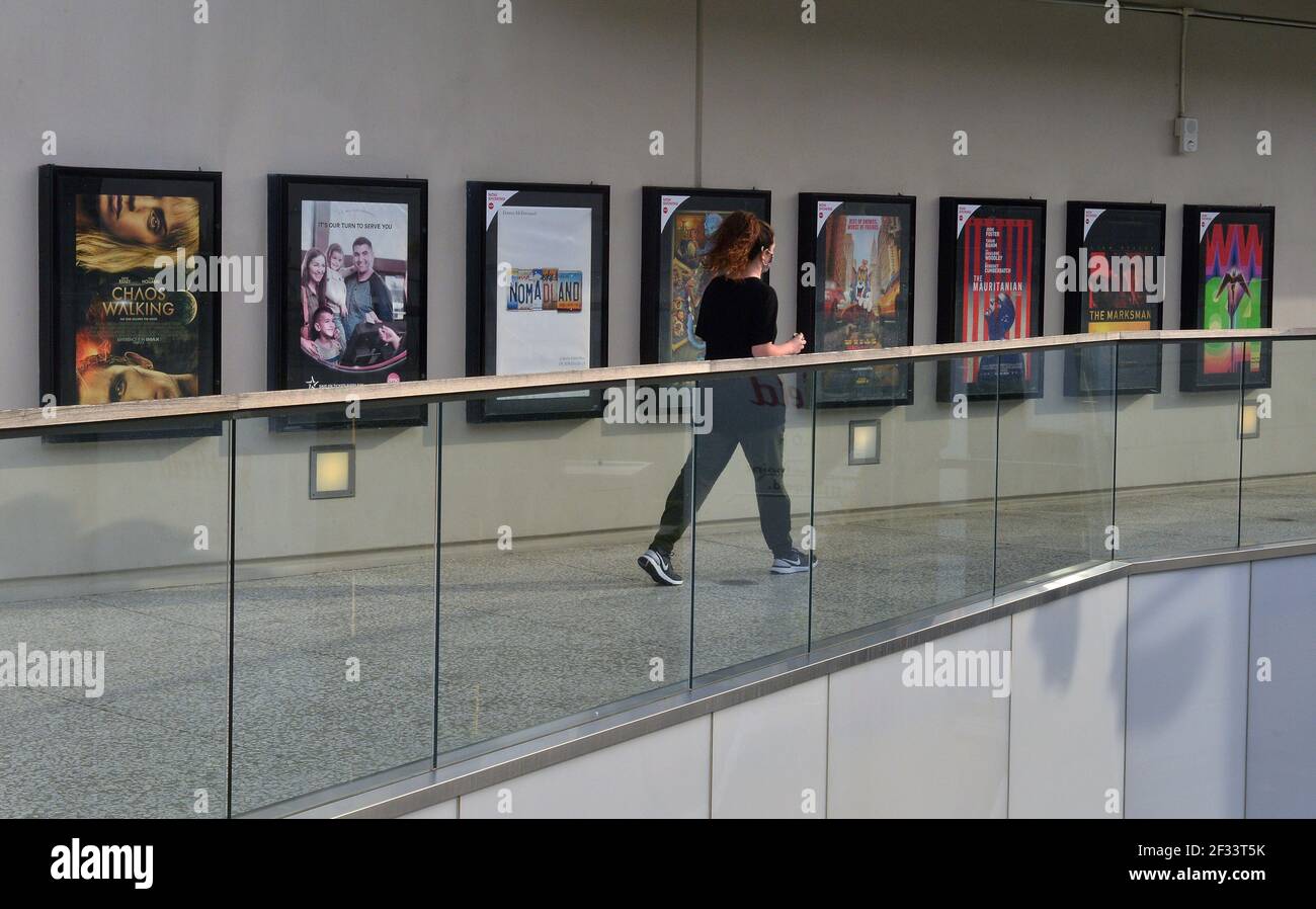 A woman walks past posters of recently released movies at the AMC Theatre in the Westfield Century City mall in Los Angeles on Sunday, March 14, 2021. AMC Theatres, one of the largest movie chains in the United States, will reopen two of its flagship locations in the Los Angeles market; the Burbank 16 and Century City 15 multiplexes today. Moviegoers in the entertainment and film capital of the world can finally watch films in theaters again after nearly a year of closures and restrictions brought on by the coronavirus pandemic. Photo by Jim Ruymen/UPI Stock Photo