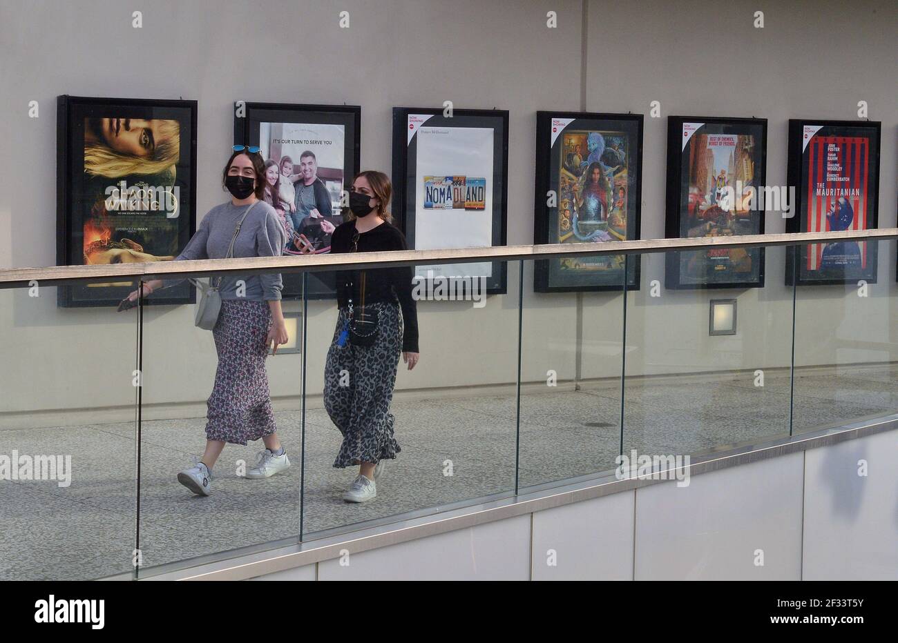 Two women walk past posters of recently released movies at the AMC Theatre in the Westfield Century City mall in Los Angeles on Sunday, March 14, 2021. AMC Theatres, one of the largest movie chains in the United States, will reopen two of its flagship locations in the Los Angeles market; the Burbank 16 and Century City 15 multiplexes today. Moviegoers in the entertainment and film capital of the world can finally watch films in theaters again after nearly a year of closures and restrictions brought on by the coronavirus pandemic. Photo by Jim Ruymen/UPI Stock Photo