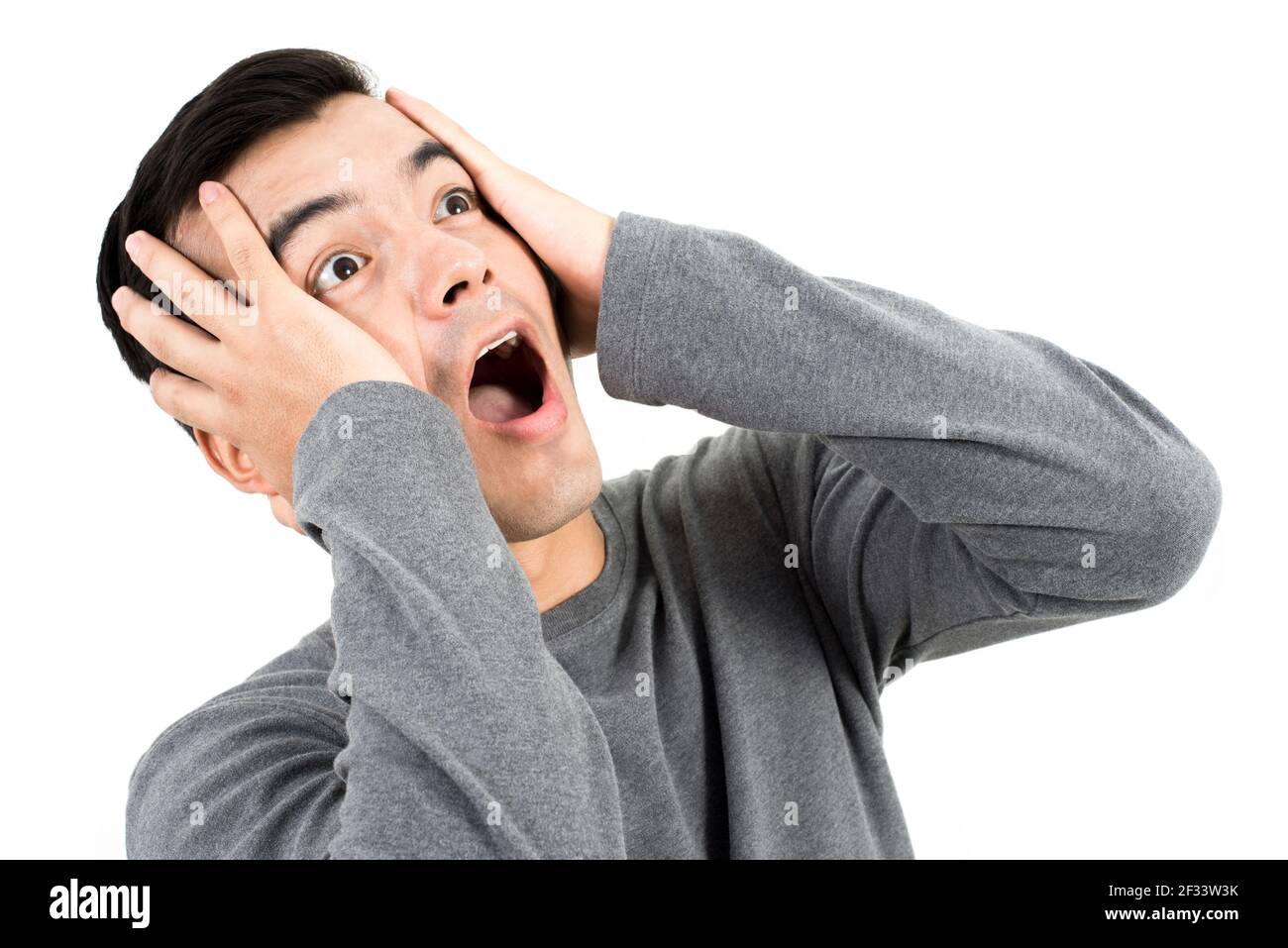 Young Man Expressing Shocked Face With Hand On His Heads Stock Photo