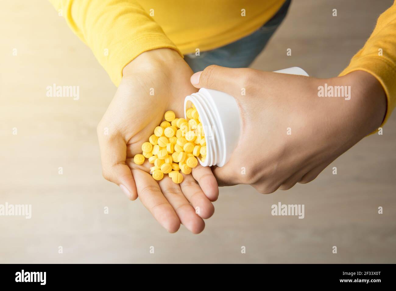 Woman pouring a lot of pills into her hand - drug addict and overdose concepts Stock Photo