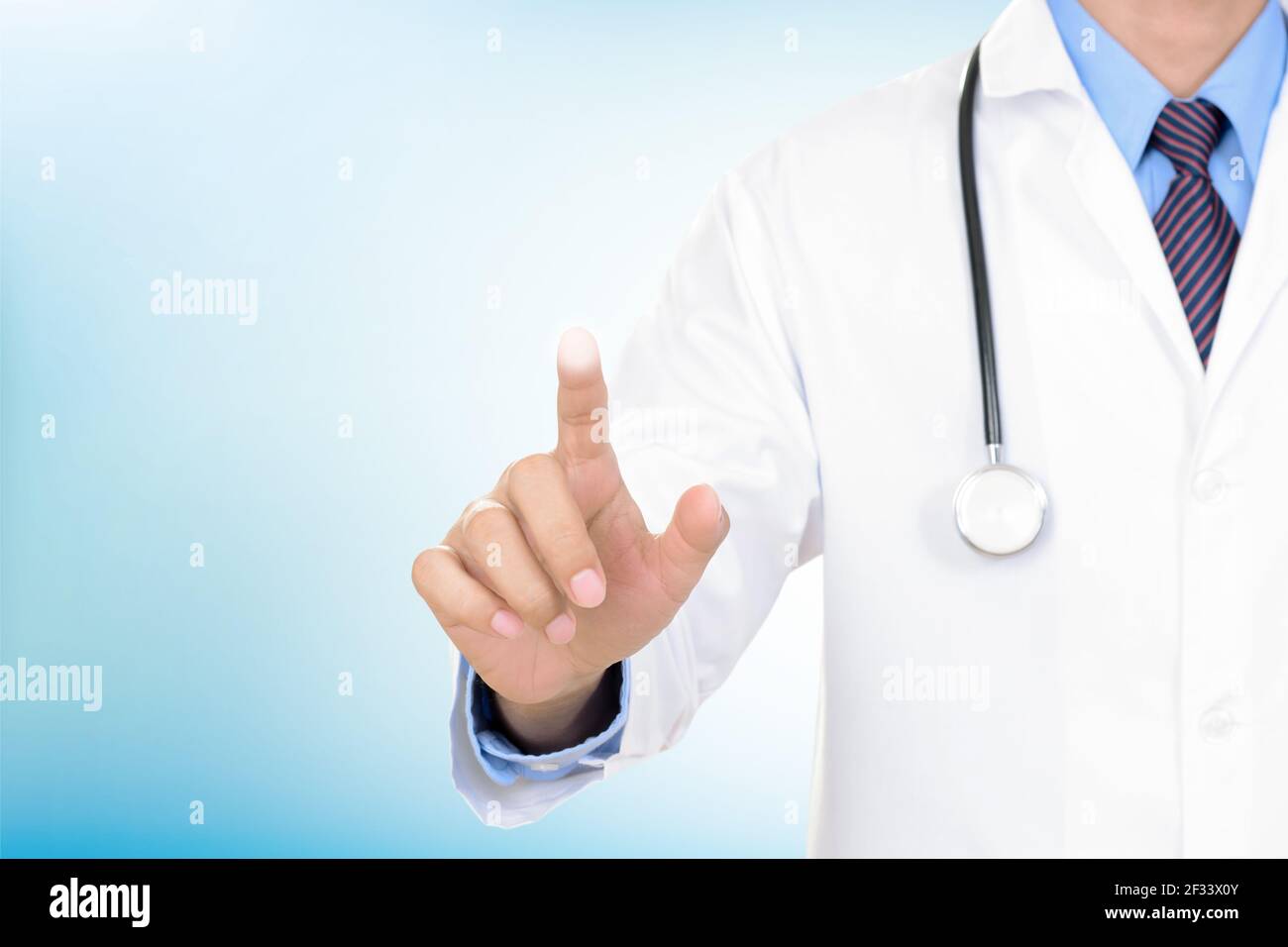 Doctor hand touching empty virtual screen on light blue background Stock Photo