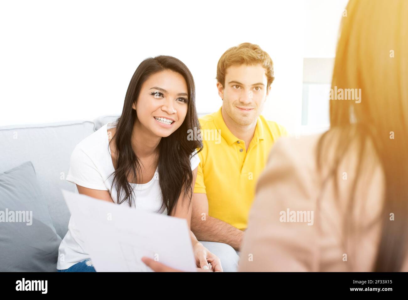 Young interracial couple meeting with consultant (or counselor, financial adviser, real estate agent etc.) Stock Photo