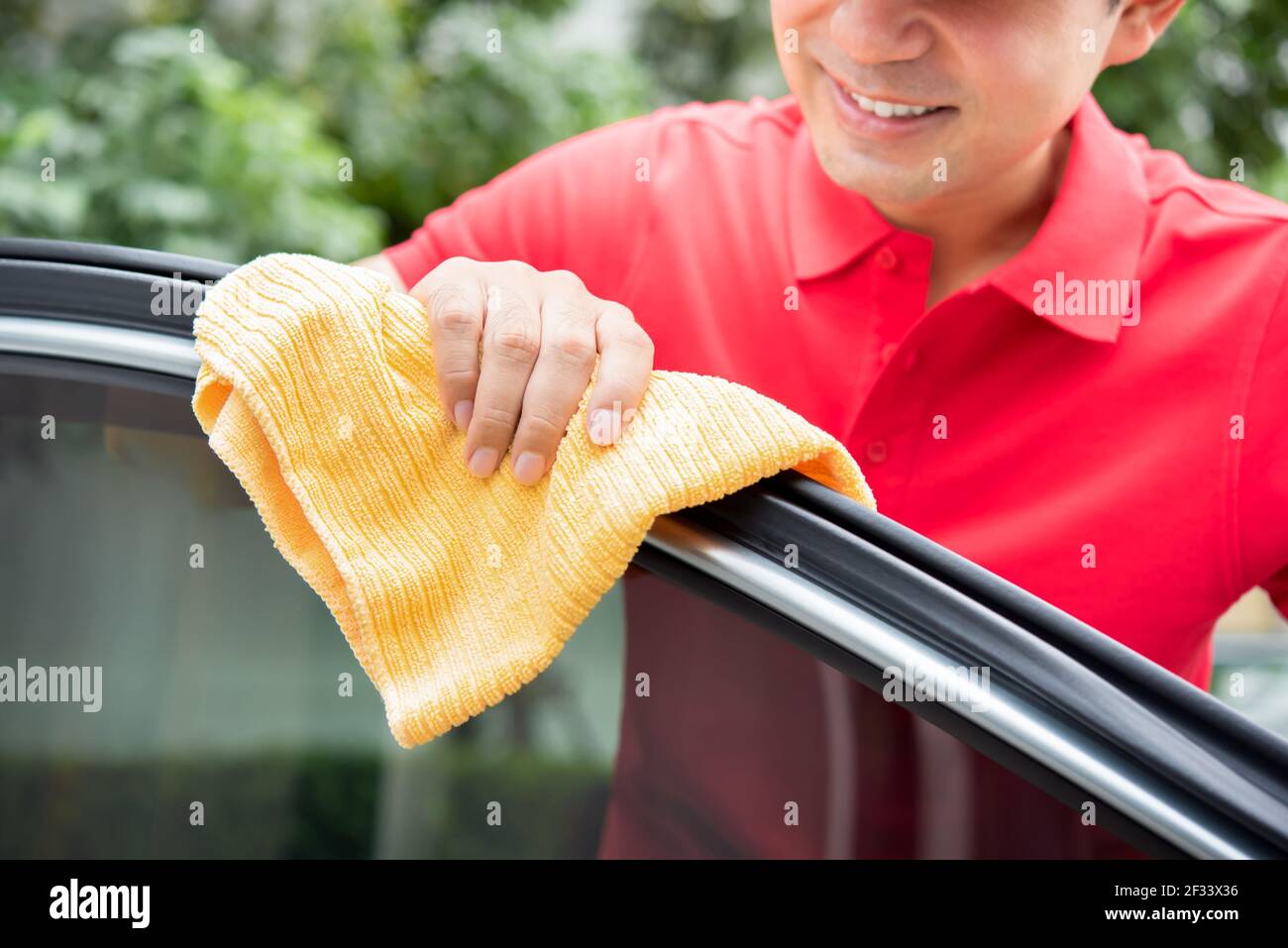 A man cleaning car door - car detailing and valeting concept Stock Photo