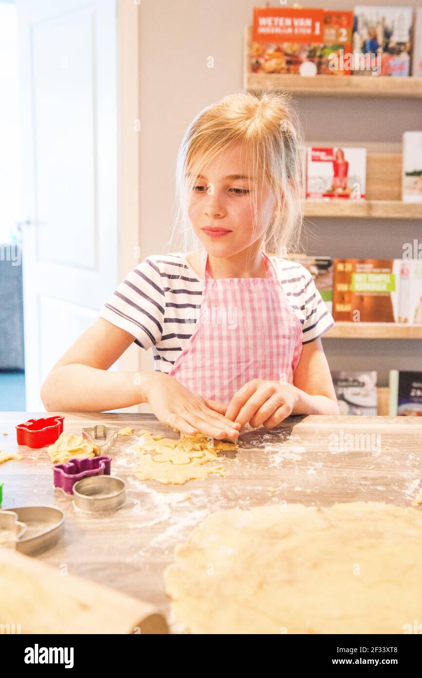 Kaatsheuvel, Netherlands. Schoolgirl Yara baking cookies inside her home kitchen Stock Photo