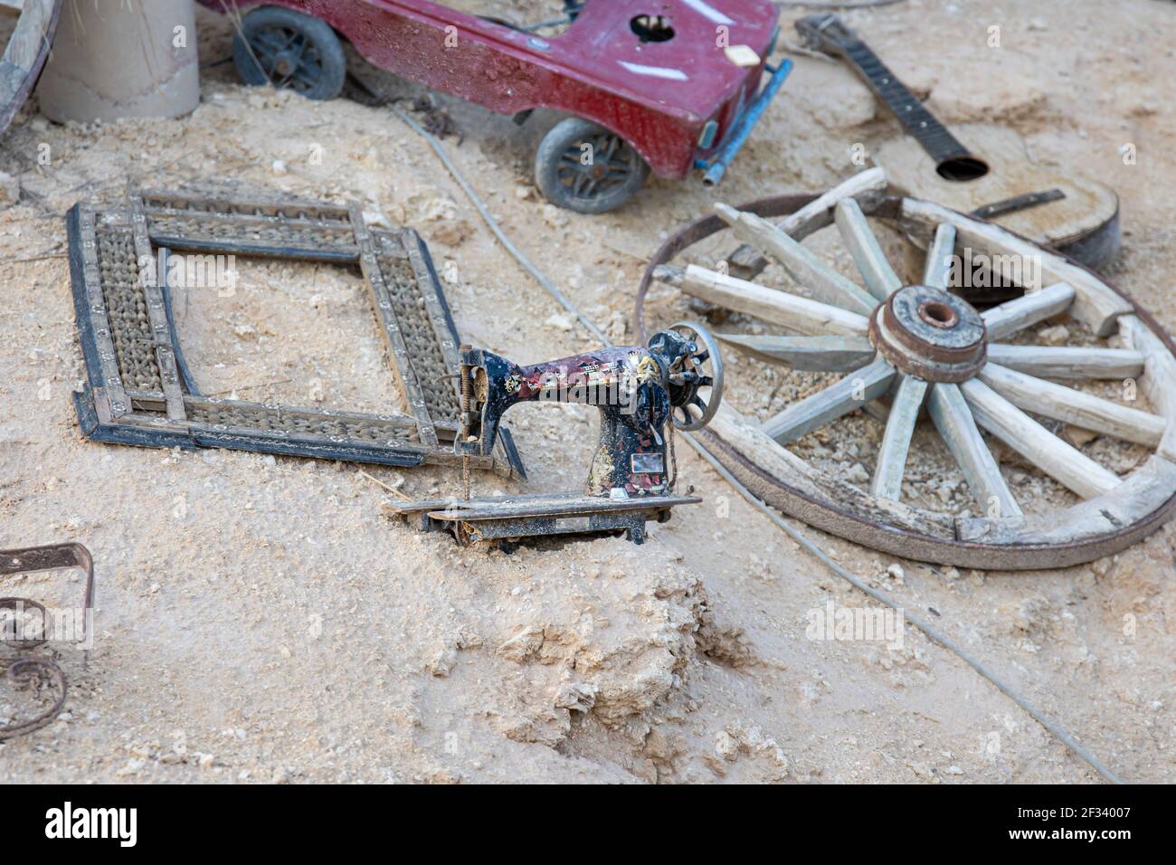 Various old junk scattered in the sand. Fragment of design of popular Farsha cafe in Sharm El Sheikh, Egypt. Stock Photo