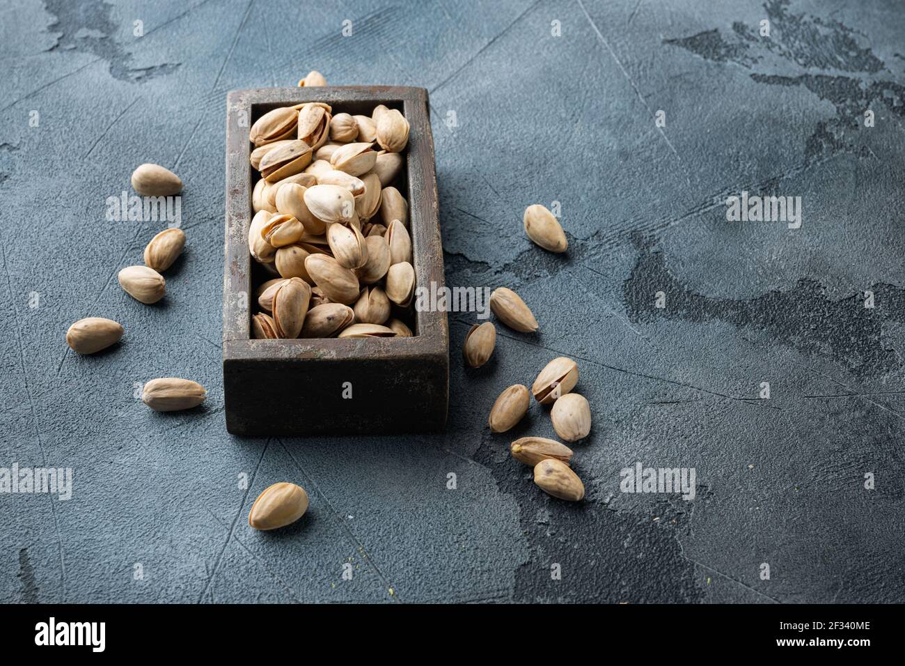 Shelled, unsalted pistachios, on grey background with space for text