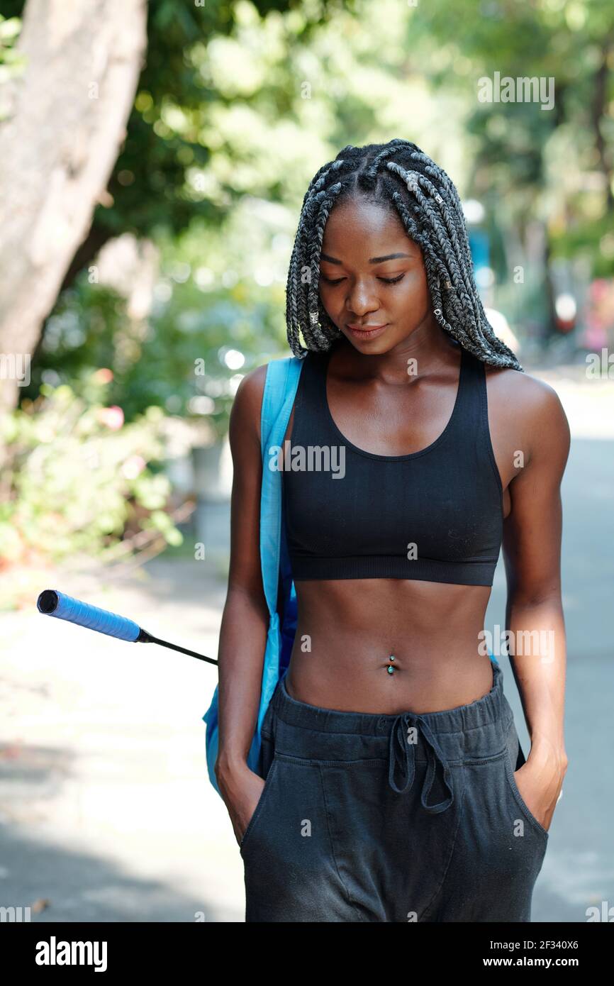 Fit slim young Black woman walking to court with gym bag and badminton  racket Stock Photo - Alamy