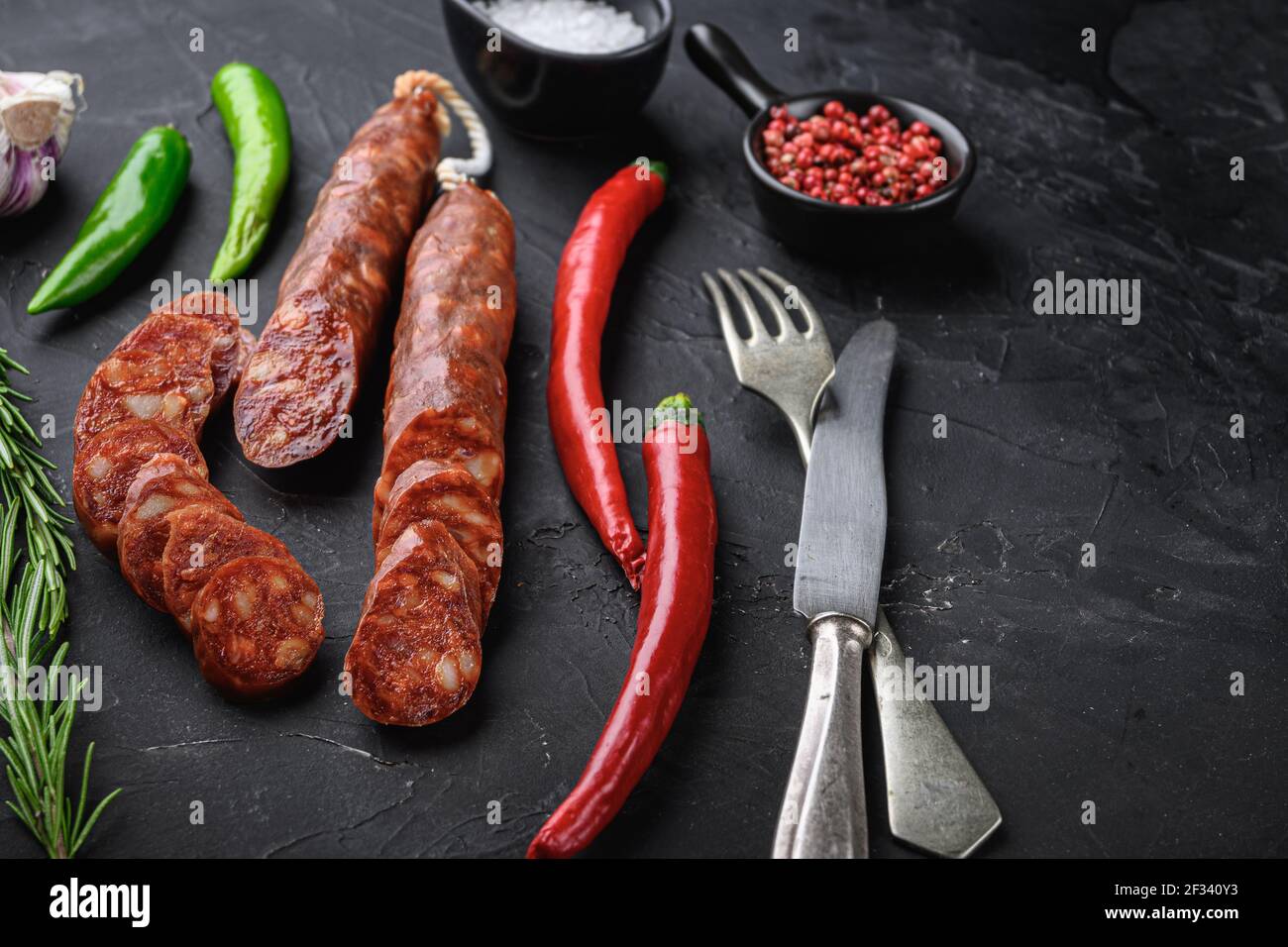 Spanish chorizo sausage slices with herbs and spices on balck ...