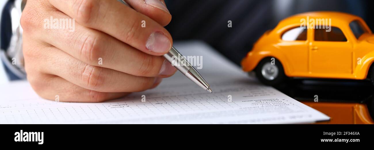 Male arm in suit sign insurance form lying on table Stock Photo Alamy
