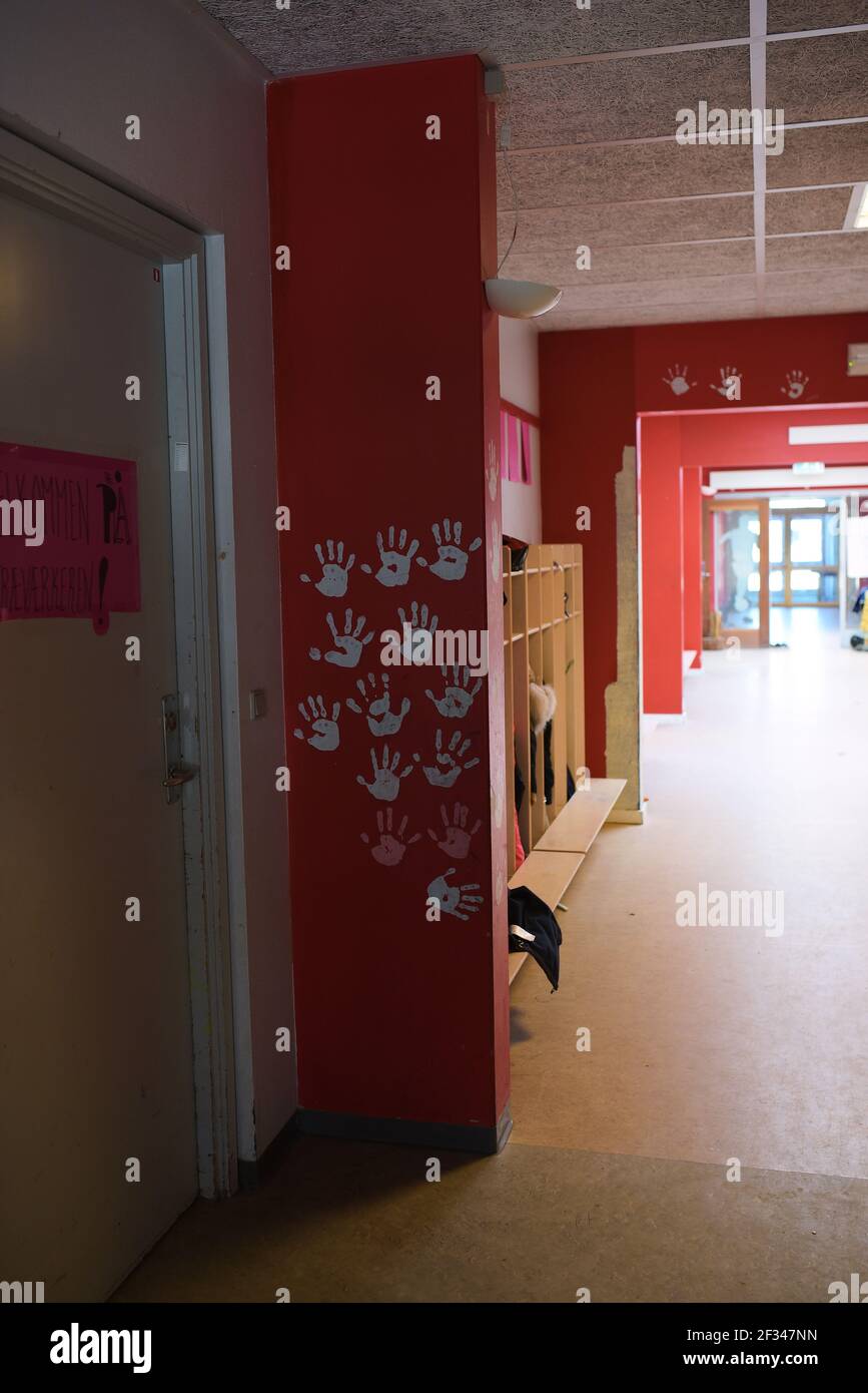 Empty hallway in school with red walls and painted hands Stock Photo