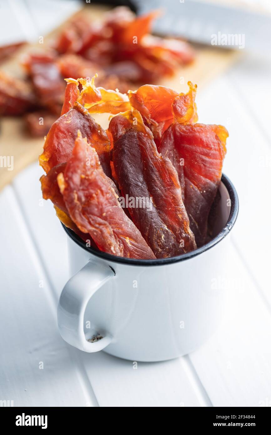 Dried chicken meat. Tasty jerky meat in cup. Stock Photo