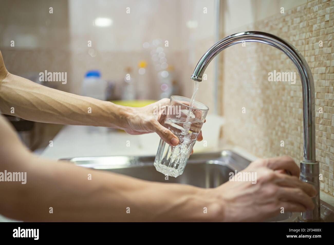 Fill a drinking glass with tap water Stock Photo