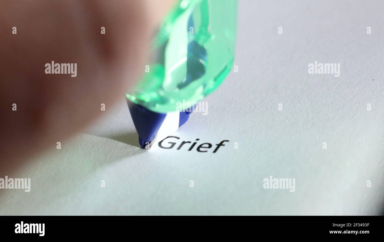 the word grief about to be removed, covered up, deleted or erased by white correction tape Stock Photo
