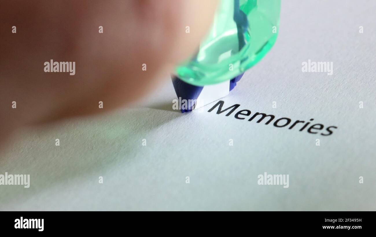 The word memories about to be covered up erased and removed by white correction tape. Memory life journey and history concept Stock Photo