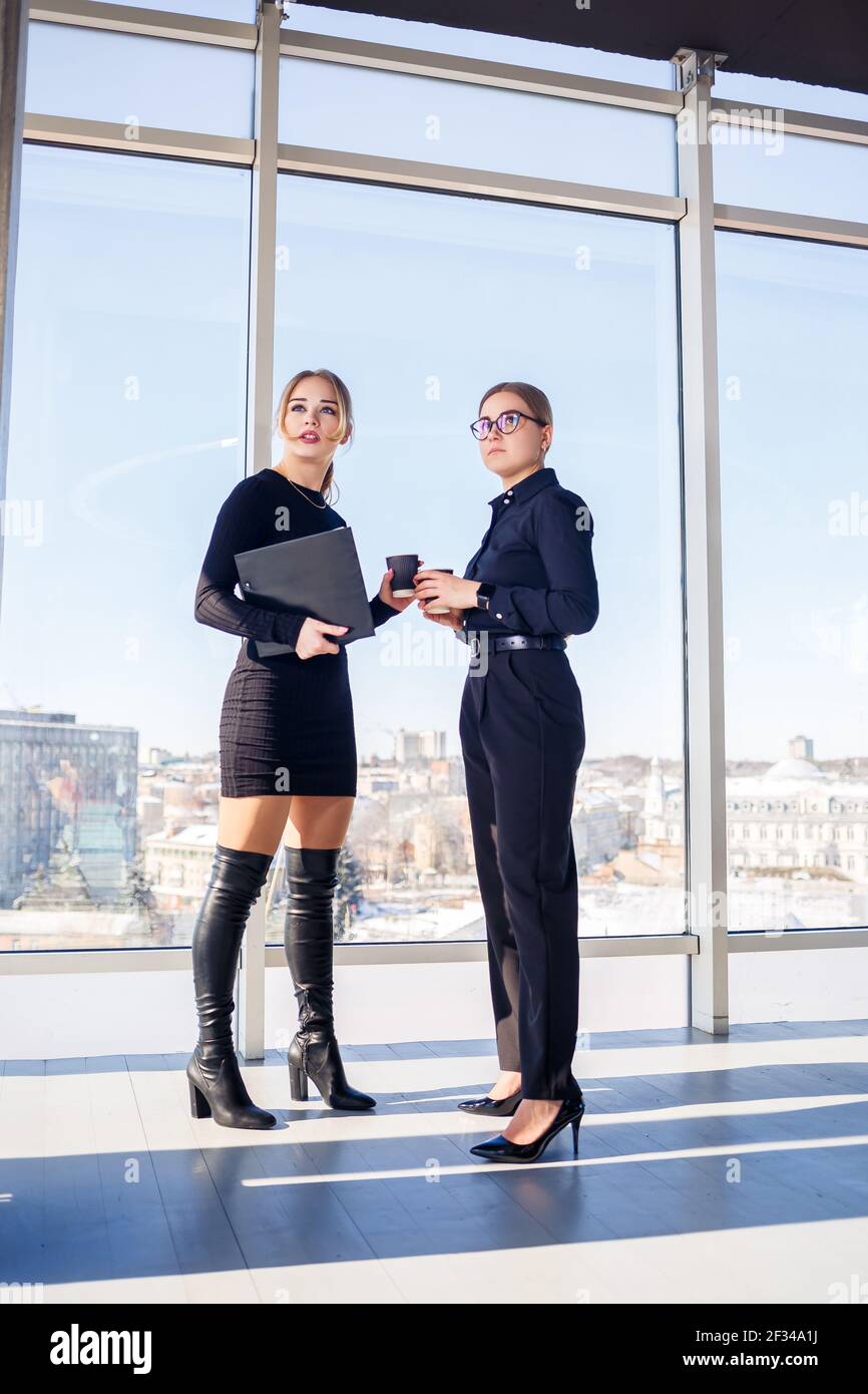 Two successful female managers talking about a joint project while ...