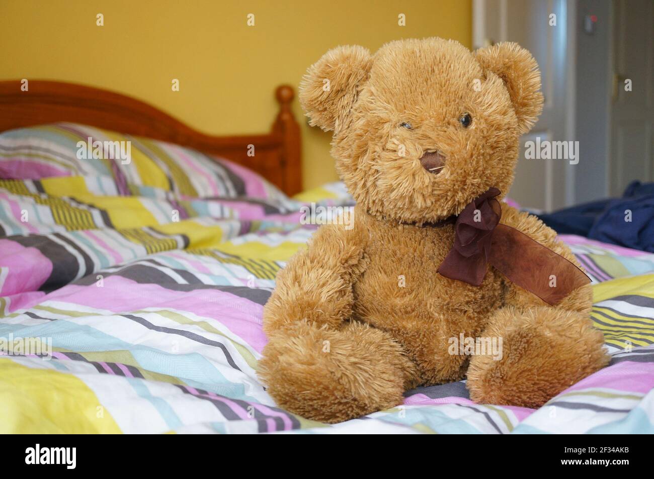 A teddybear sitting on a bed Stock Photo - Alamy
