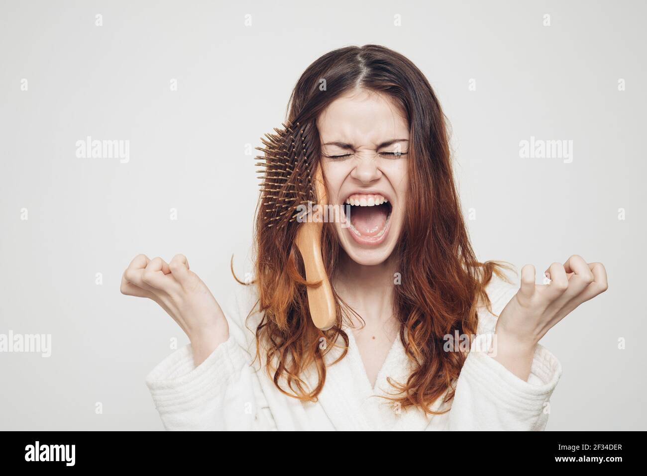 woman combing hair brittle ends split ends health problems Stock Photo