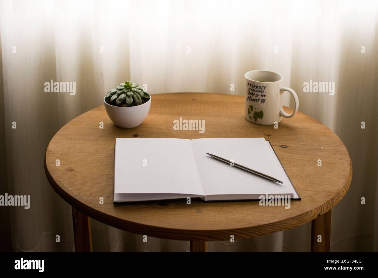 Minimalist work space at home, with cup of coffee and open blank notebook on top of the desk Stock Photo